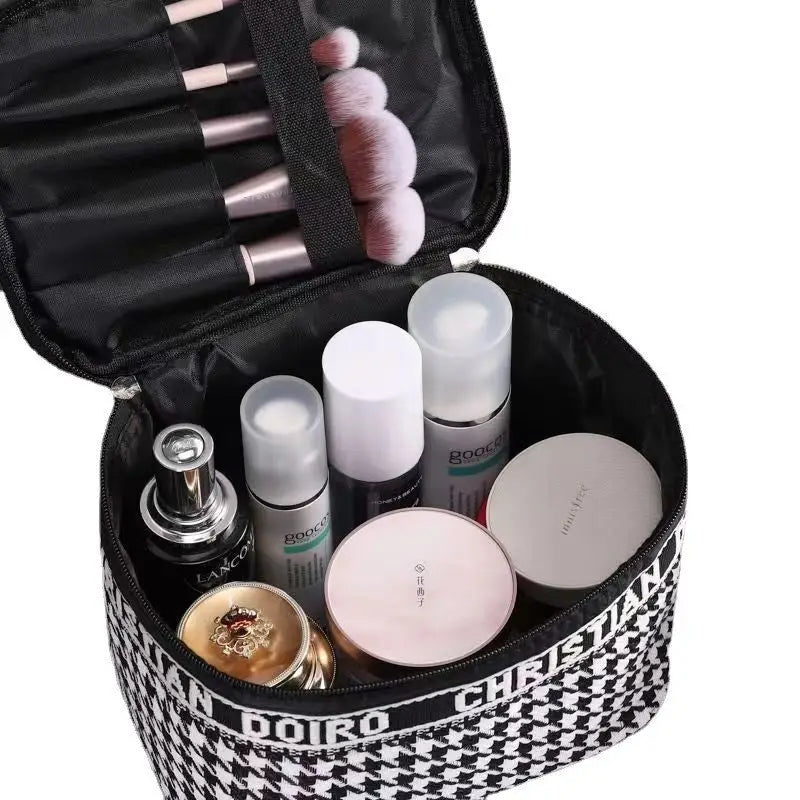 Trousse à maquillage ouverte, intérieur noir avec cosmétiques et accessoires visibles.