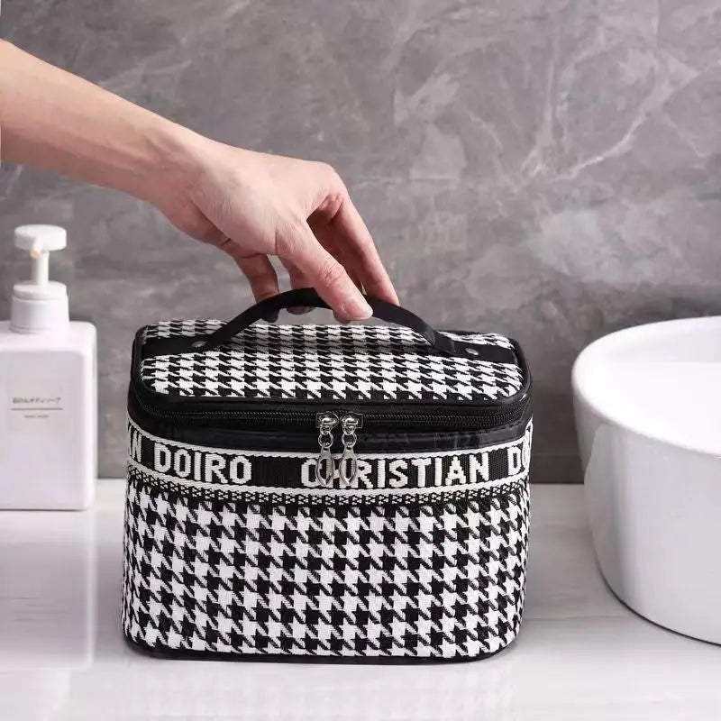 Trousse à maquillage rigide pied-de-poule noir et blanc, zip et poignée.