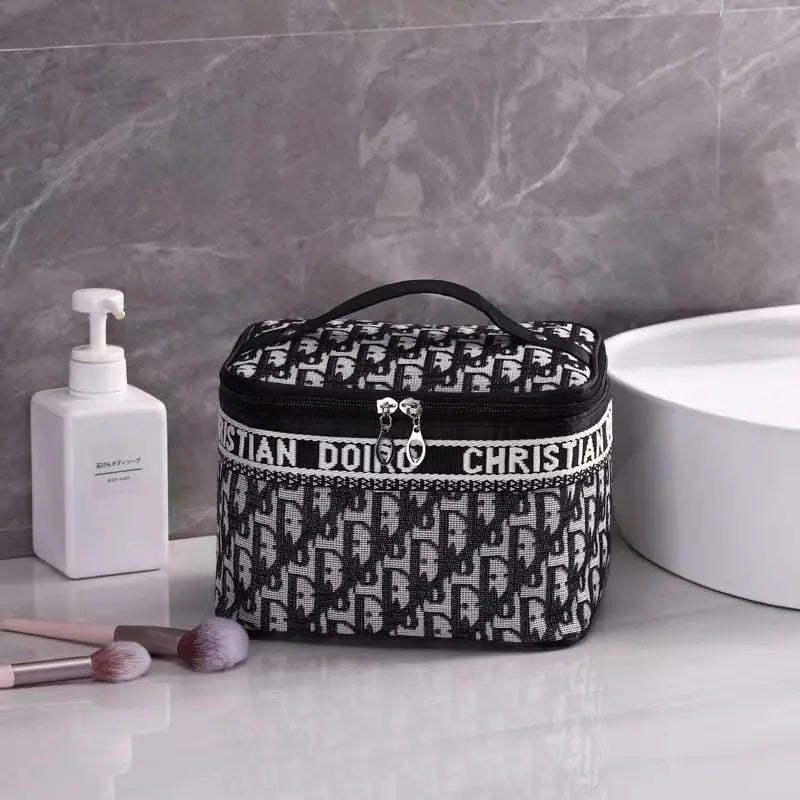 Trousse à maquillage à motif logo noir et blanc, poignée arrondie et fermeture éclair.