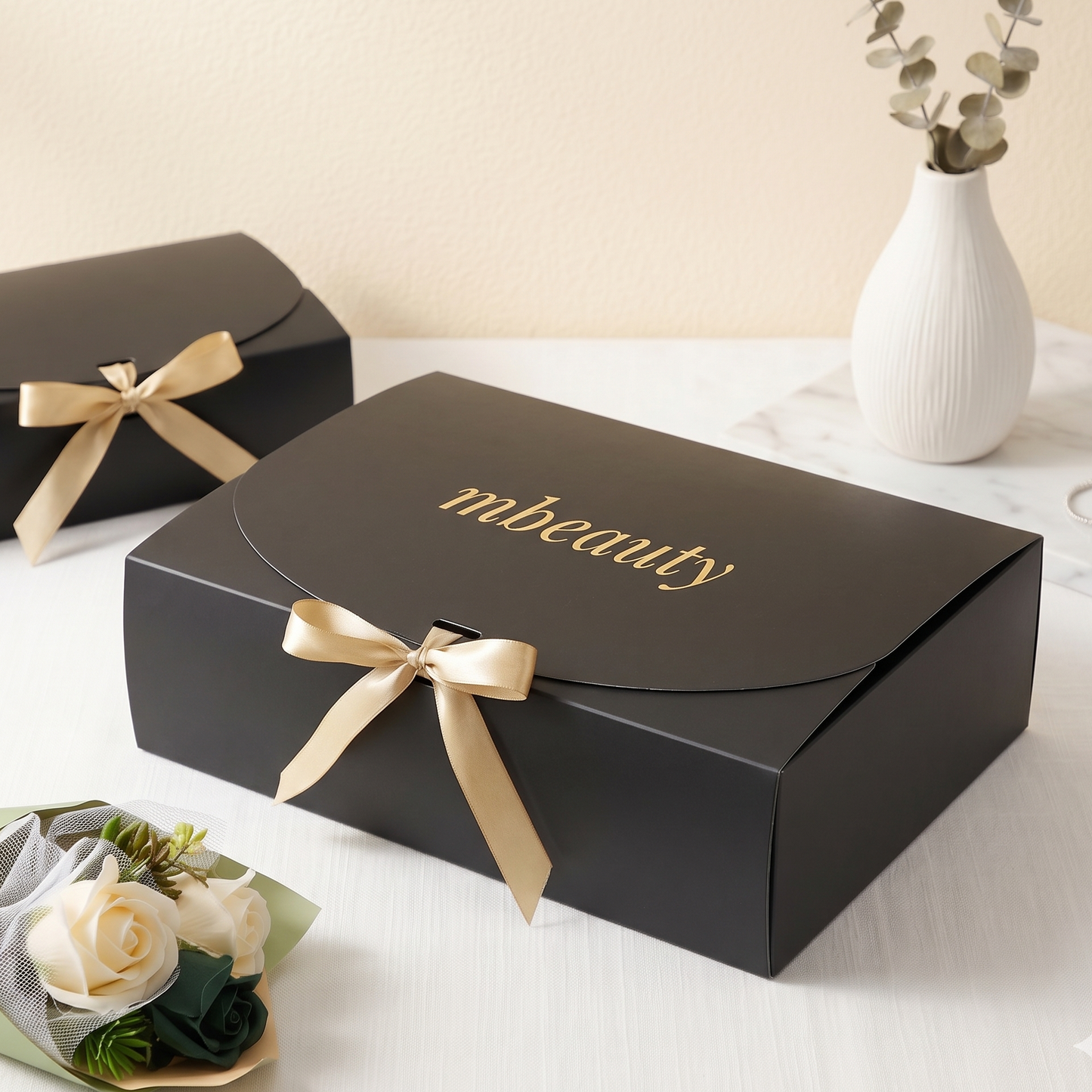 Boîte de beauté Mbeauty noire avec ruban doré et logo mbeauty sur le couvercle
