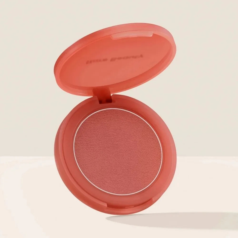 Blush en boîtier compact ouvert, fard rose cuivré et pastille visible