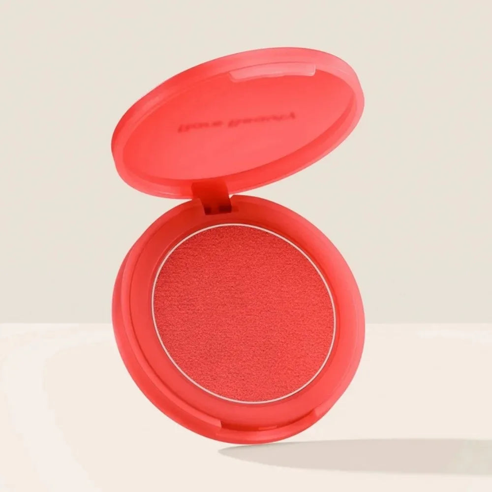 Blush en boîtier compact ouvert, fard rouge corail et pastille visible