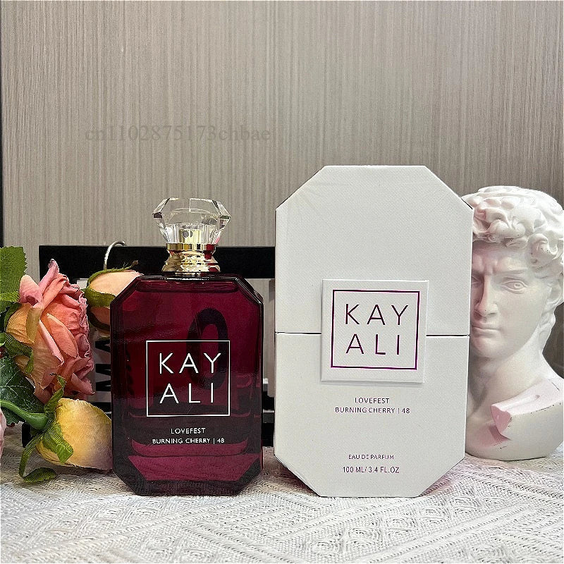 Parfum Kayali Lovefest bordeaux en flacon hexagonal avec bouchon doré et boîte blanche