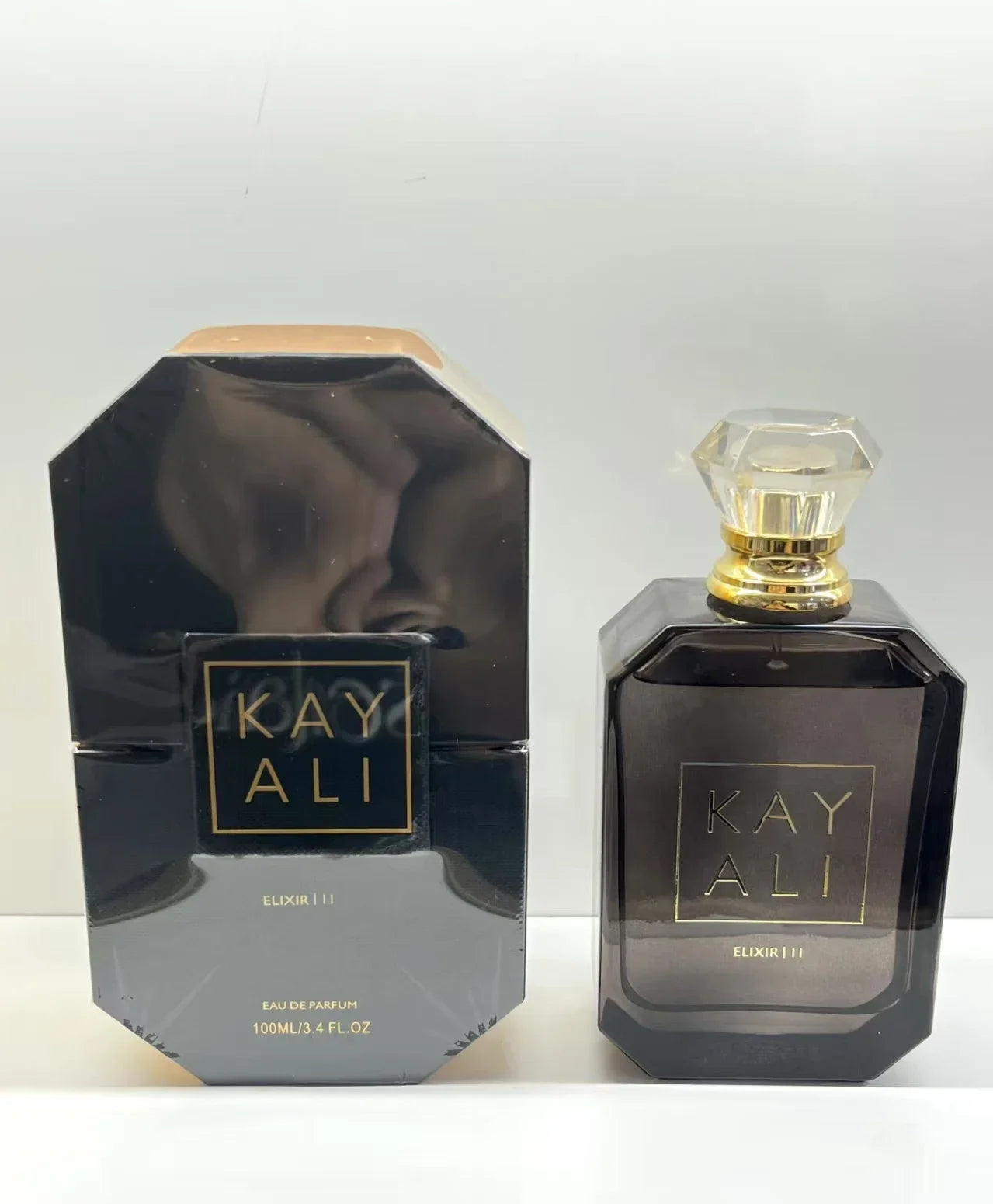 Parfum Kayali Elixir 11, flacon rectangulaire noir fumé avec capuchon doré, 100 ml.