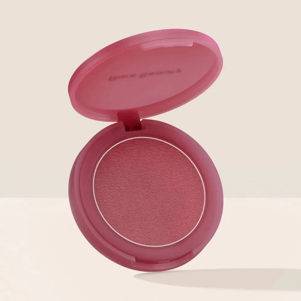 Blush en boîtier compact ouvert, fard rose foncé et pastille visible