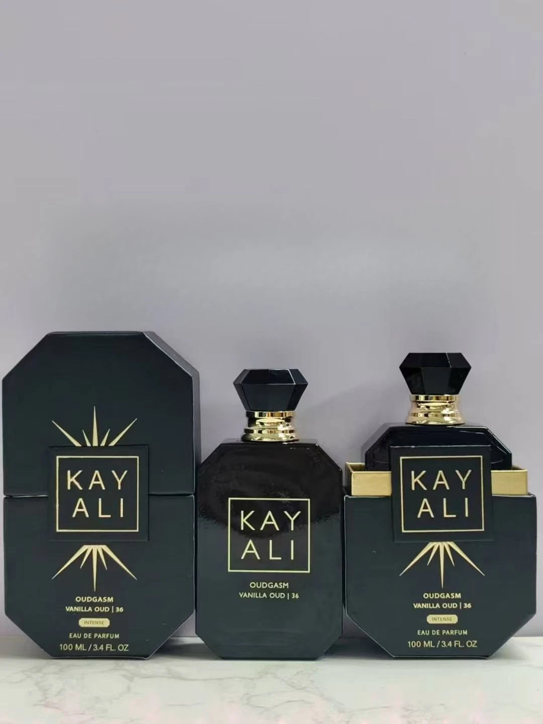 Parfum Kayali noir en flacons hexagonaux avec bouchons dorés et boîtes