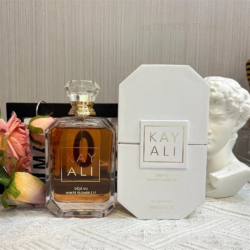 Parfum Kayali Déjà Vu ambré en flacon hexagonal avec bouchon transparent et boîte blanche