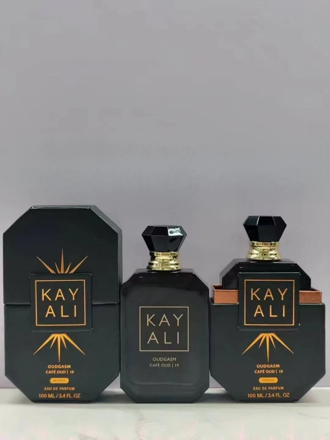 Parfum Kayali OUDGASM Cafe Oud 19, flacons noirs à capuchon doré, boîte noire, 100 ml.