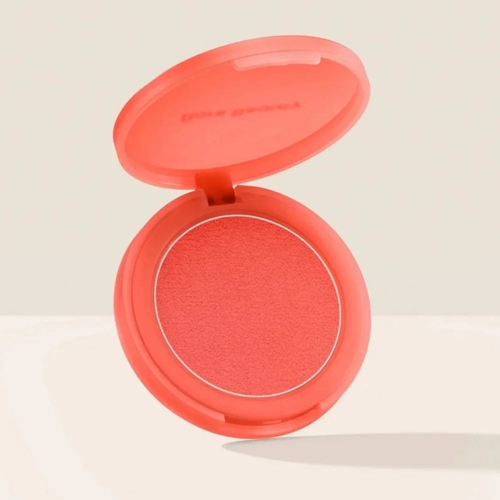 Blush en boîtier compact ouvert, fard corail rouge rosé et pastille visible